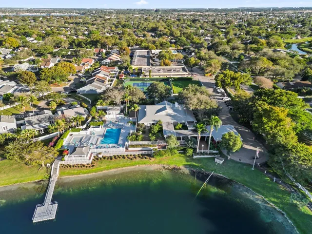 an aerial view of residential houses with outdoor space and trees