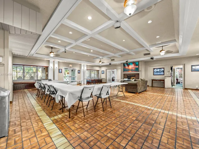 a dining hall with lots of tables a large window and chairs