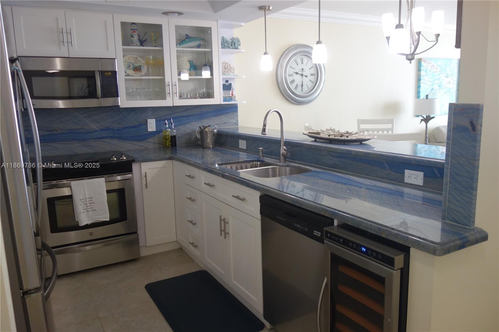 5701 Collins Avenue, Unit 1510 Miami Beach, FL 33140 - Photo 1 of 67 a kitchen with stainless steel appliances granite countertop a sink and stove top oven