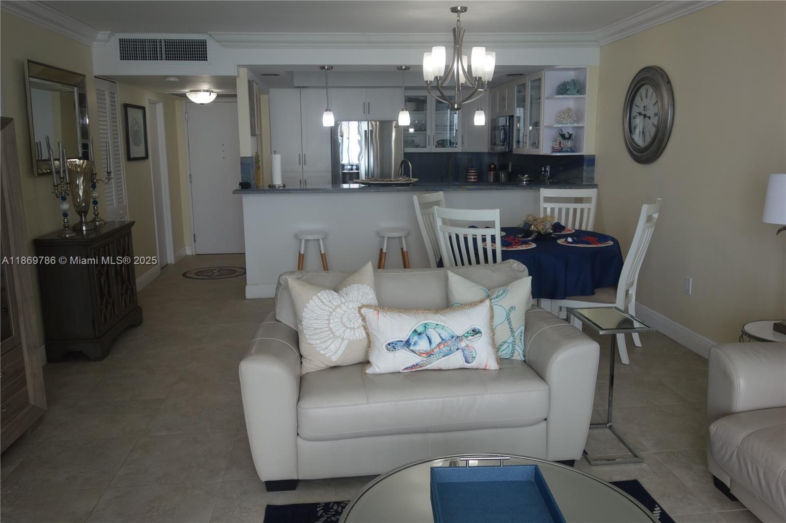 5701 Collins Avenue, Unit 1510 Miami Beach, FL 33140 - Photo 13 of 67 a living room with furniture and a chandelier