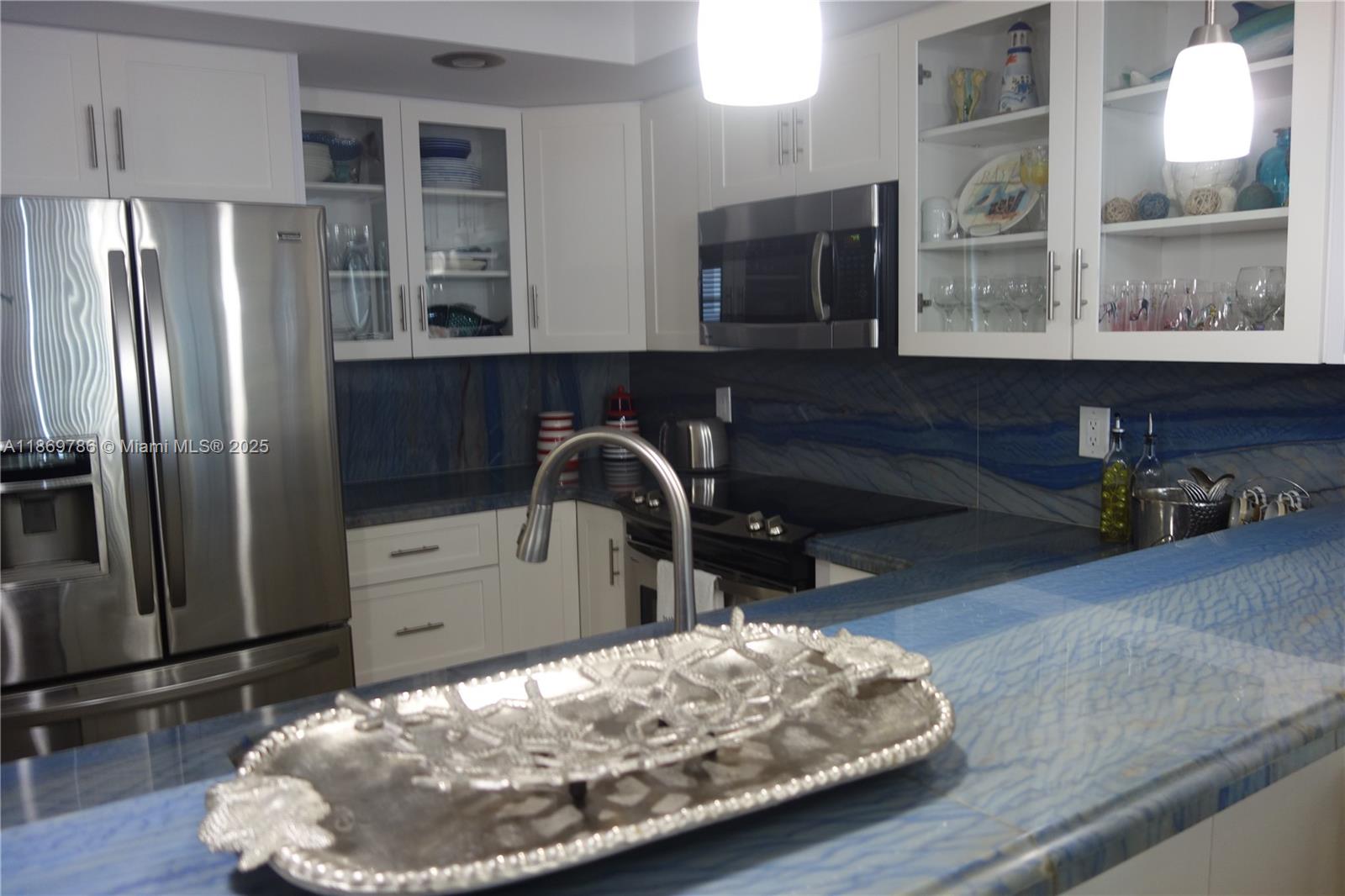 5701 Collins Avenue, Unit 1510 Miami Beach, FL 33140 - Photo 2 of 67 a kitchen with stainless steel appliances wooden floor and a refrigerator