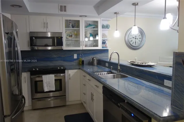 a kitchen with granite countertop stainless steel appliances a stove and a sink