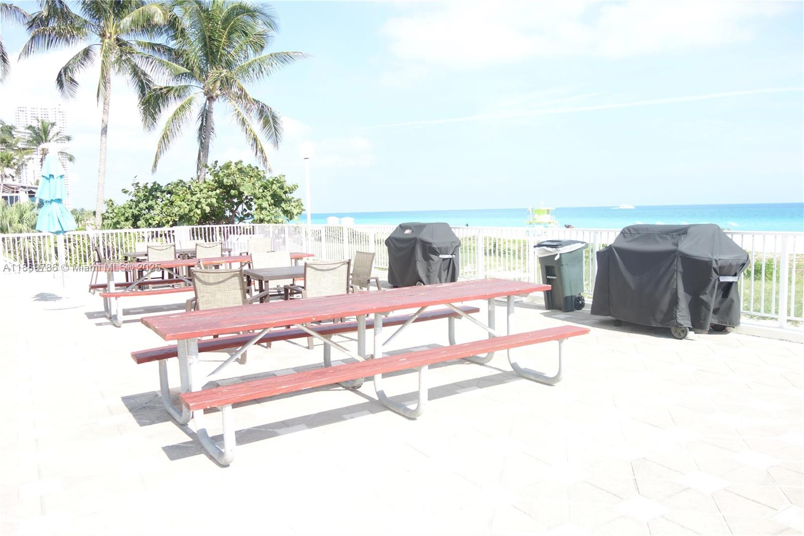 5701 Collins Avenue, Unit 1510 Miami Beach, FL 33140 - Photo 49 of 67 a swimming pool with an outdoor seating and a yard