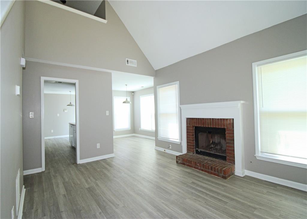 957 Oak Street Southwest Atlanta, GA 30310 - Photo 4 of 17 an empty room with wooden floor fireplace and windows