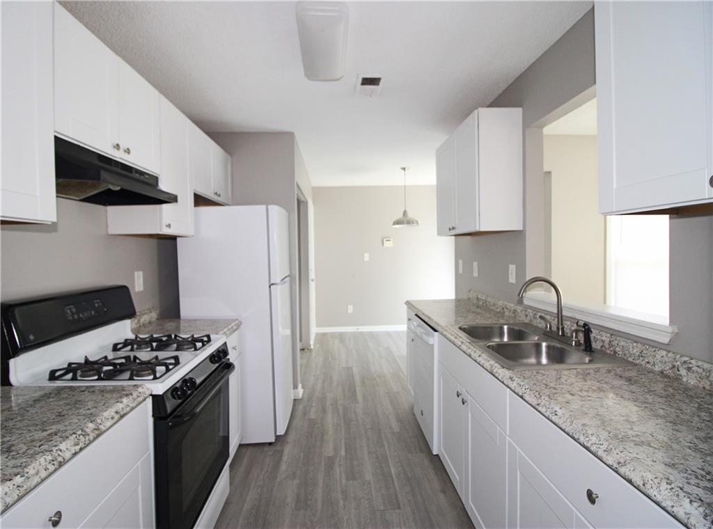957 Oak Street Southwest Atlanta, GA 30310 - Photo 6 of 17 a kitchen with stainless steel appliances granite countertop a sink stove refrigerator and cabinets