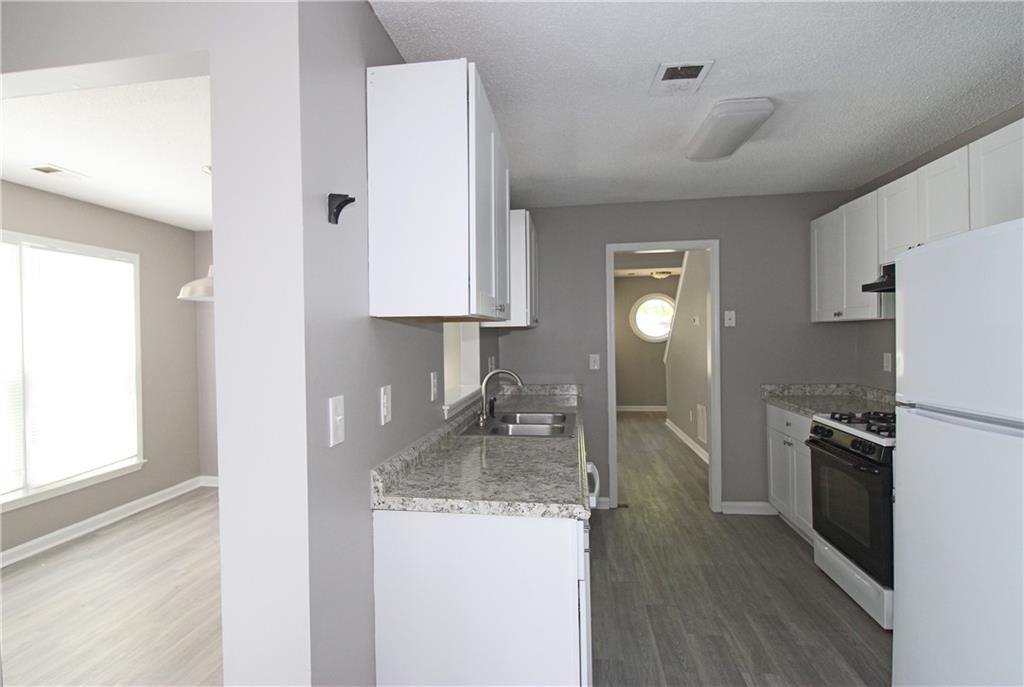 957 Oak Street Southwest Atlanta, GA 30310 - Photo 7 of 17 a kitchen with granite countertop a sink stove and refrigerator