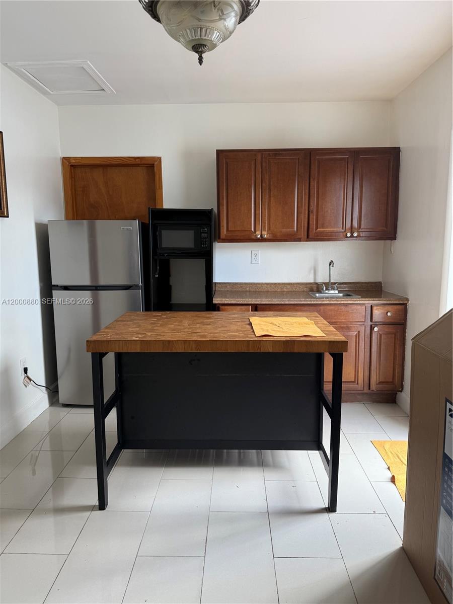 13410 Southwest 81st Street, Unit 2 Miami, FL 33183 - Photo 1 of 6 a room with a table chairs and refrigerator