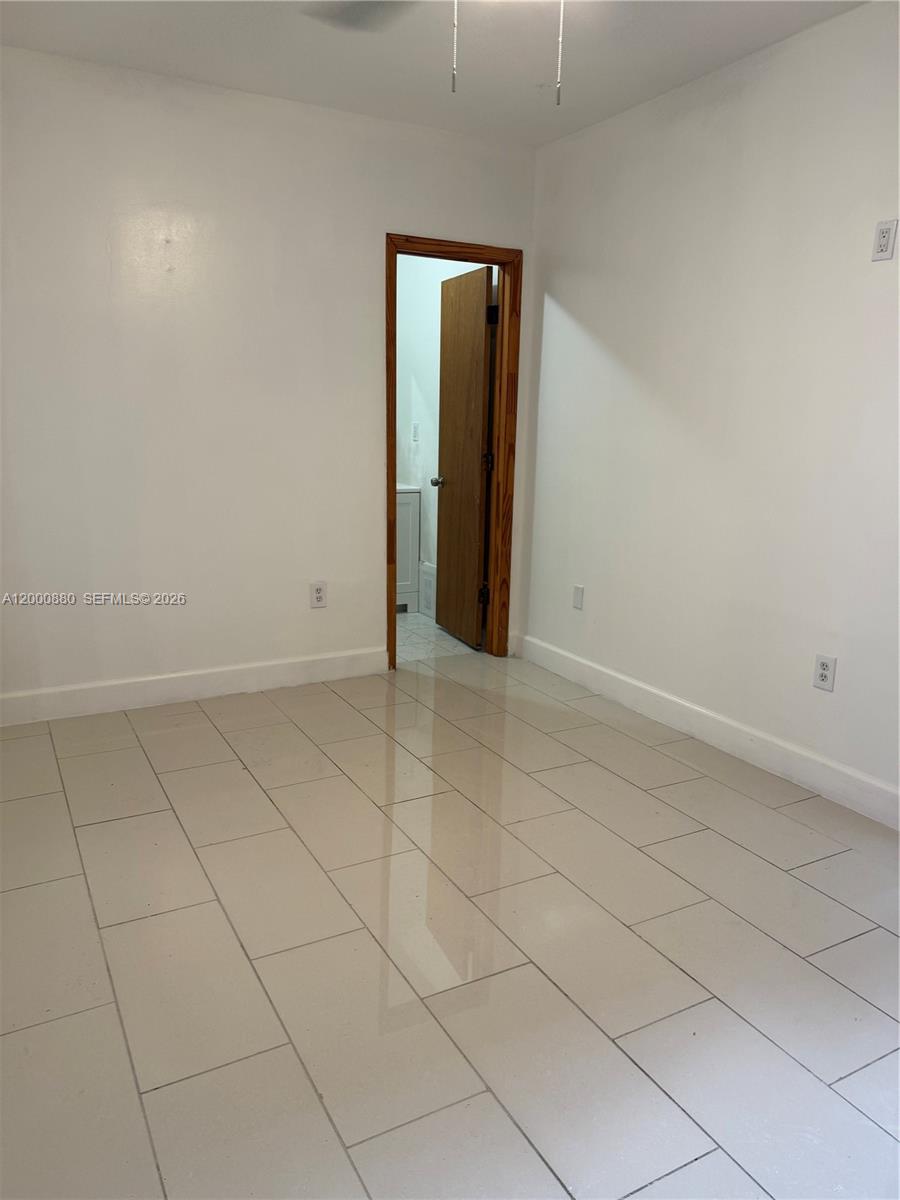 13410 Southwest 81st Street, Unit 2 Miami, FL 33183 - Photo 3 of 6 an empty room with a mirror