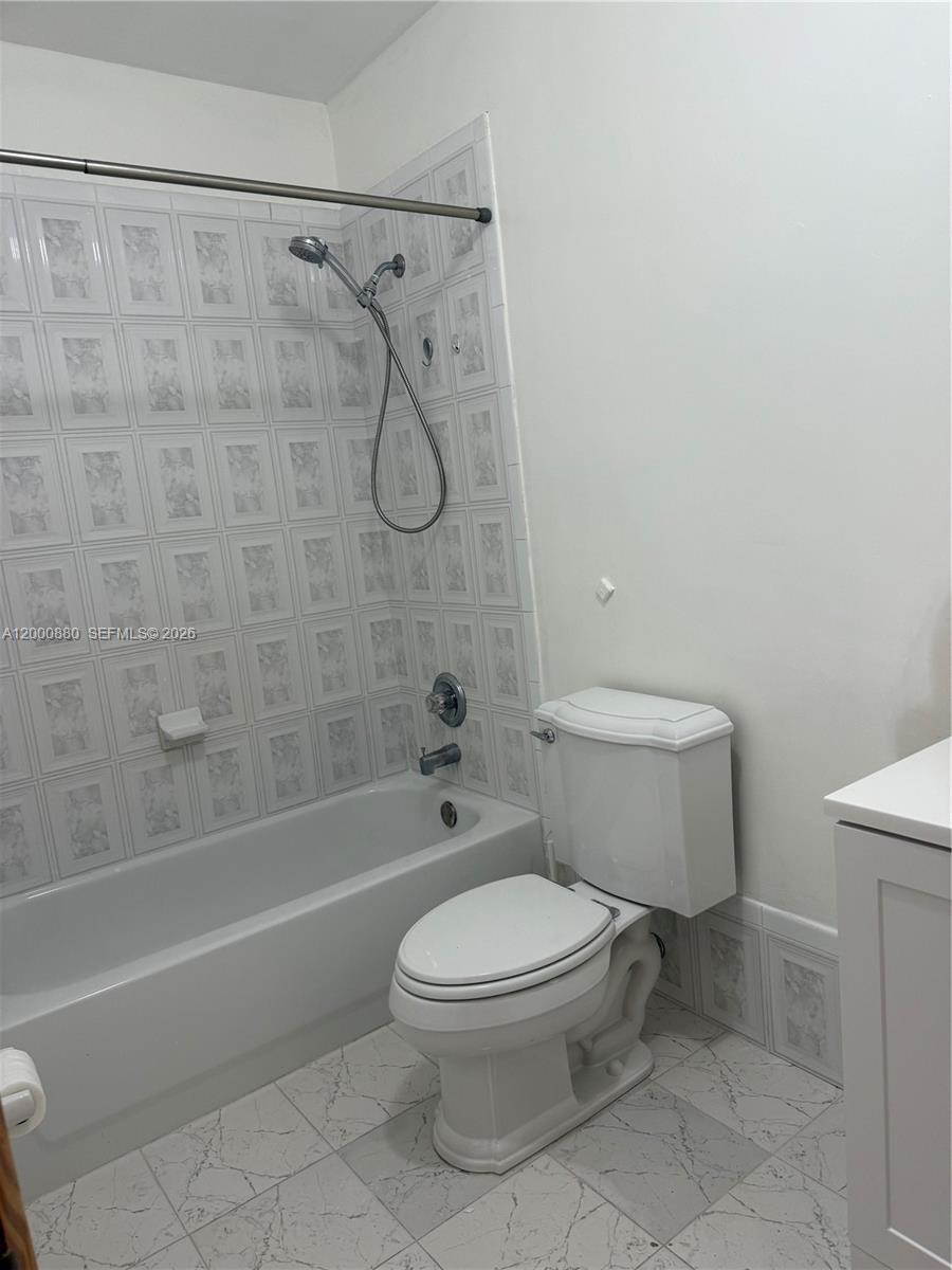 13410 Southwest 81st Street, Unit 2 Miami, FL 33183 - Photo 6 of 6 a white toilet and shower sitting next to a bathroom sink