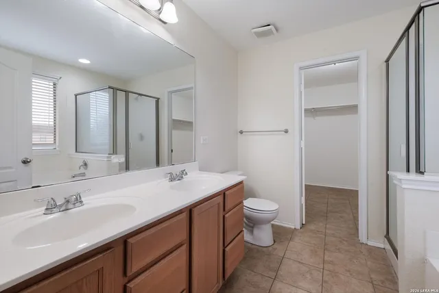 a bathroom with a sink a toilet a large mirror and vanity