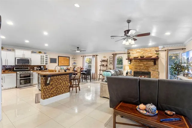 a kitchen with stainless steel appliances granite countertop a table chairs and a refrigerator
