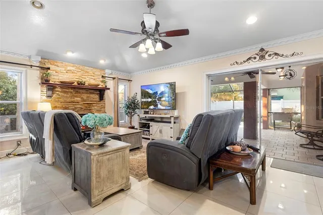 a living room with furniture a flat screen tv and a floor to ceiling window