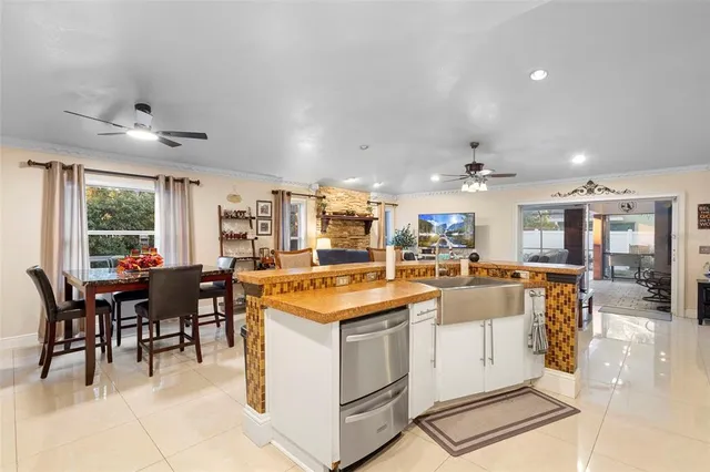 a living room with furniture kitchen view and a chandelier