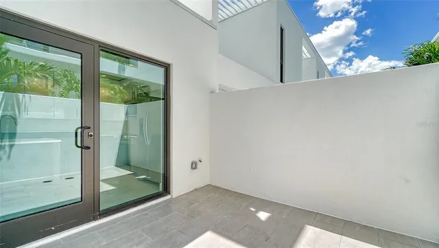 a large white kitchen with stainless steel appliances a large window