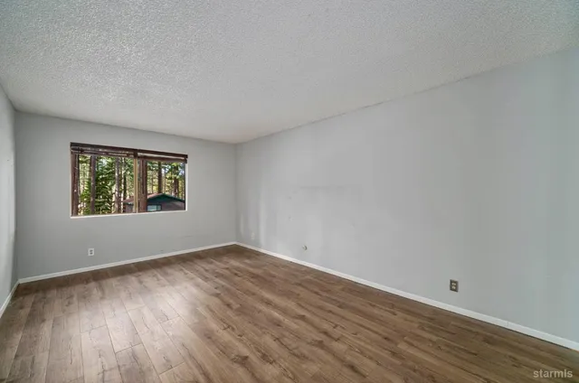 a view of a room with wooden floor and window