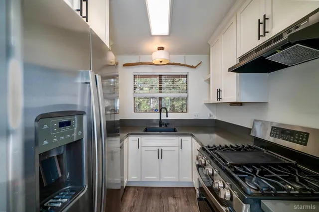 a kitchen with granite countertop a stove oven and refrigerator