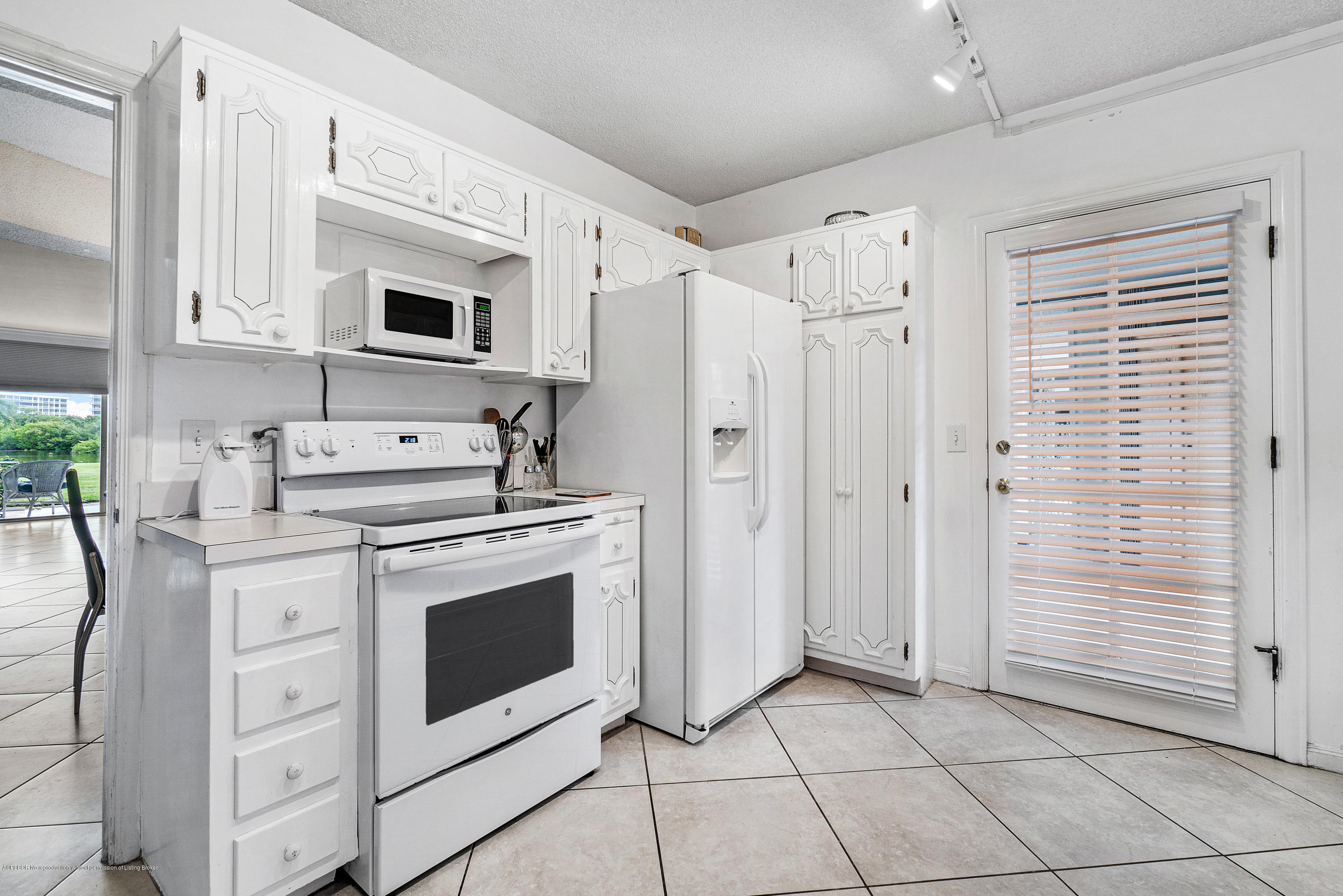 2185 Ibis Isle Road, Unit 40 Palm Beach, FL 33480 - Photo 13 of 28 a kitchen with stainless steel appliances white cabinets and white appliances