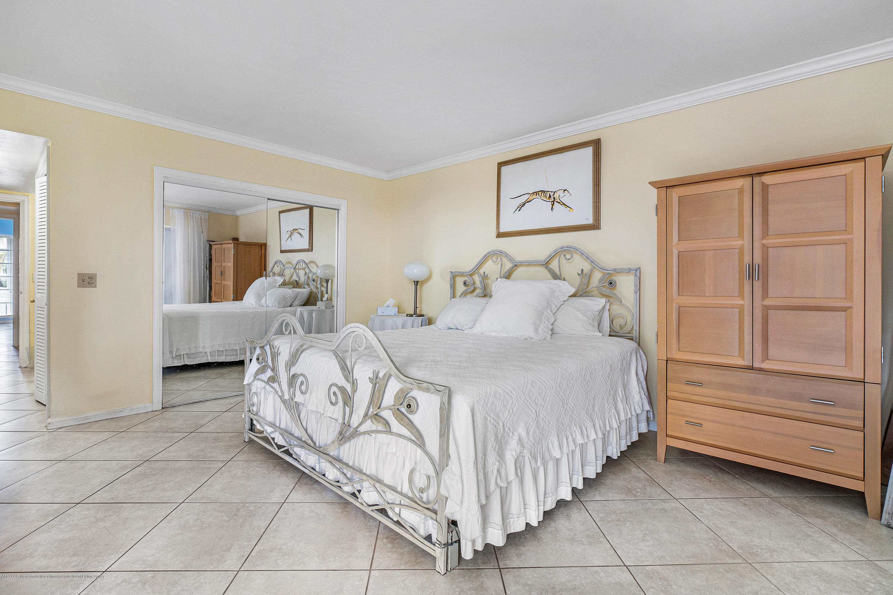 2185 Ibis Isle Road, Unit 40 Palm Beach, FL 33480 - Photo 17 of 28 a spacious bedroom with a bed and a chandelier