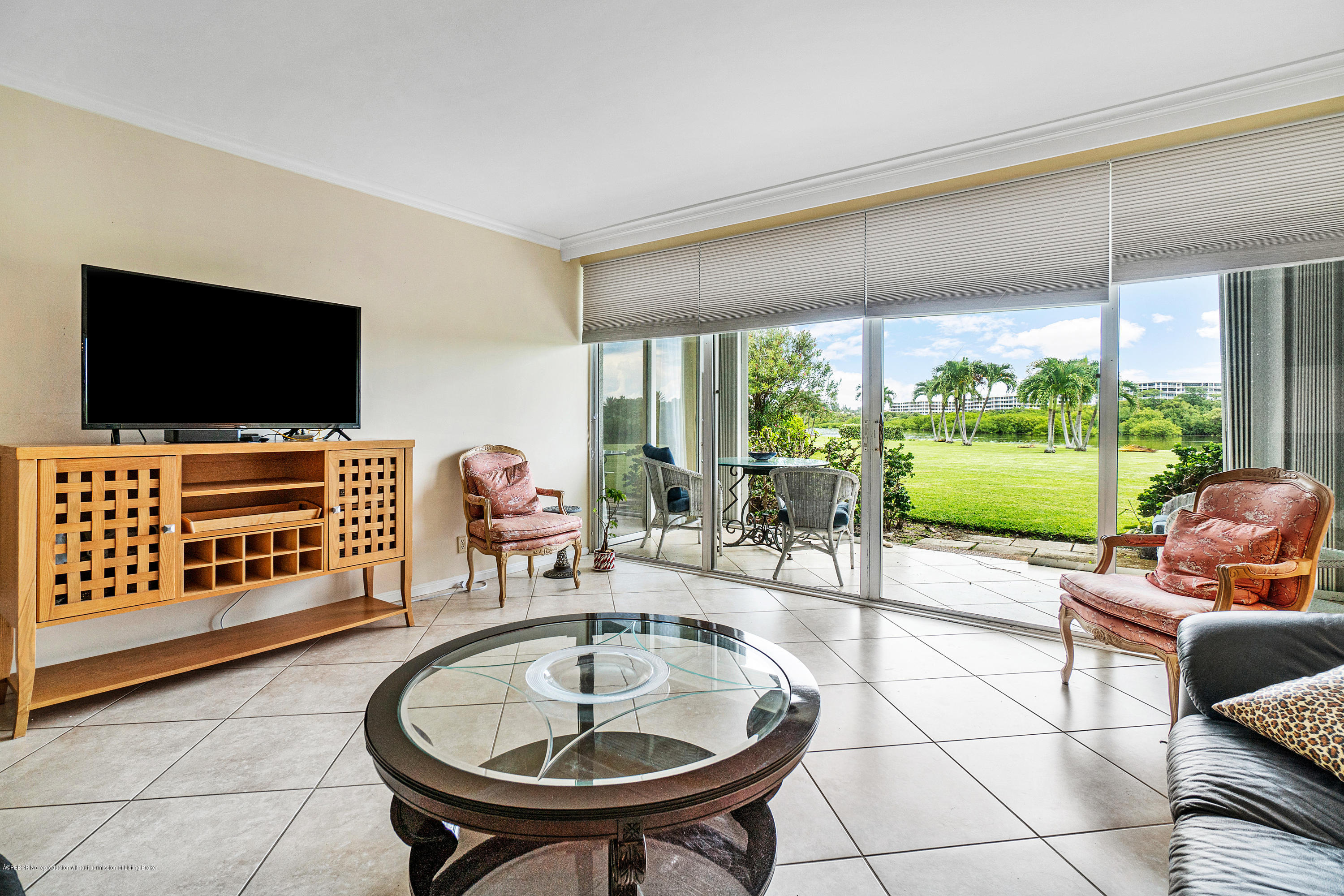 2185 Ibis Isle Road, Unit 40 Palm Beach, FL 33480 - Photo 6 of 28 a living room with furniture a flat screen tv and a floor to ceiling window