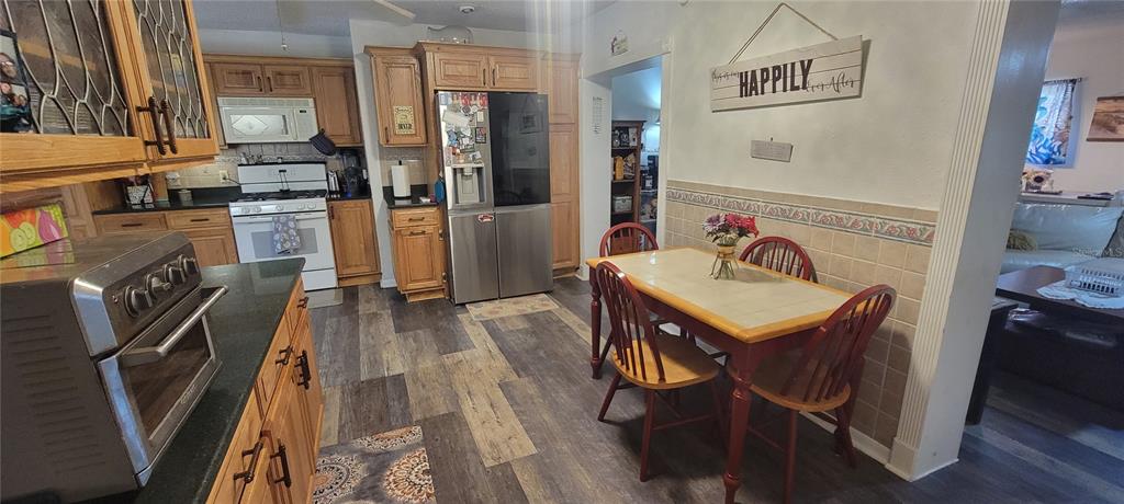 6046 East Loring Lane Inverness, FL 34452 - Photo 18 of 46 a kitchen with stainless steel appliances granite countertop a refrigerator a stove and a sink with wooden floor