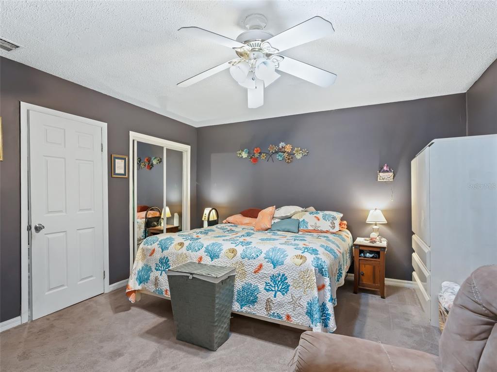 6046 East Loring Lane Inverness, FL 34452 - Photo 30 of 46 a bedroom with a bed and a chandelier