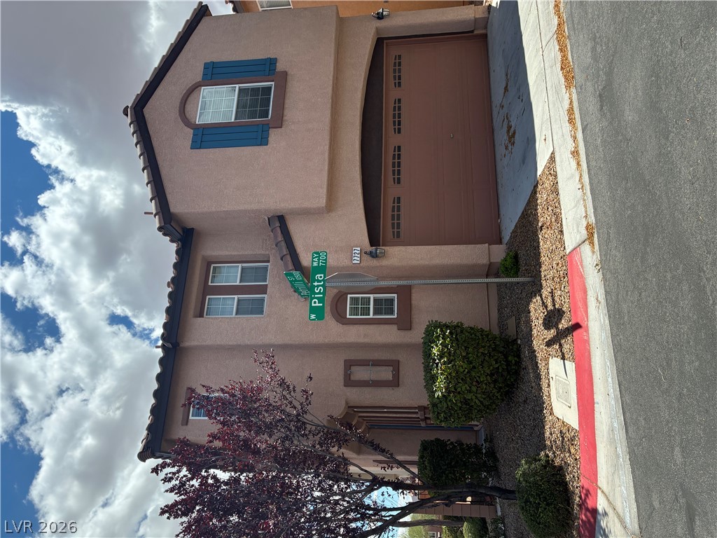 7727 Pista Way Las Vegas, NV 89179 - Photo 1 of 12 A well-maintained street presence, featuring stucco exterior, arched garage entry, and neat landscaping.