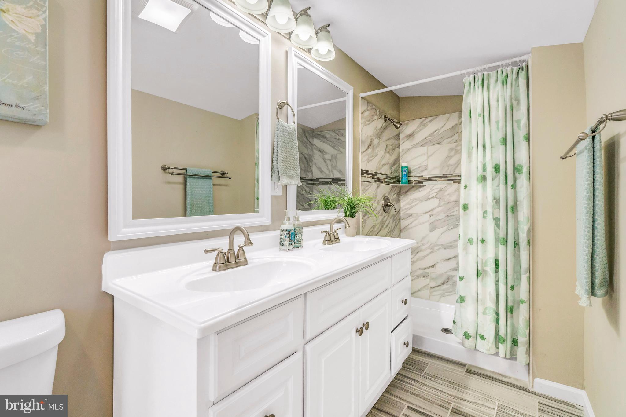 605 St Dunstans Road Baltimore, MD 21212 - Photo 23 of 43 a bathroom with a double vanity sink mirror and shower
