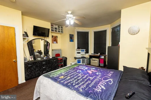 a bed room with a bed television and a dresser