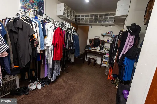 a view of walk in closet with clothes and shoes
