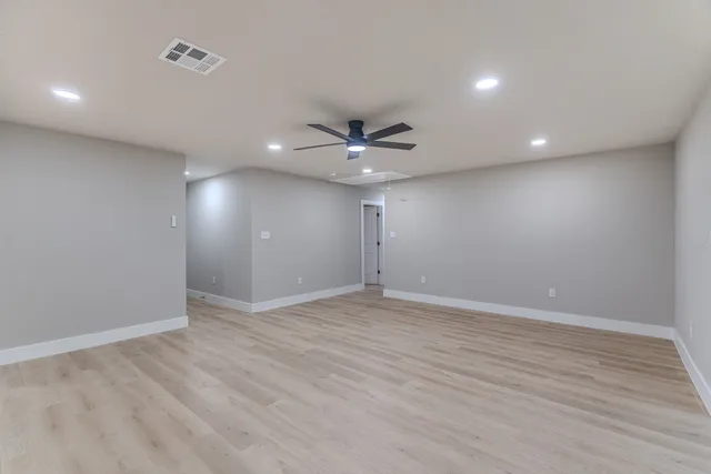 a view of an empty room with a ceiling fan
