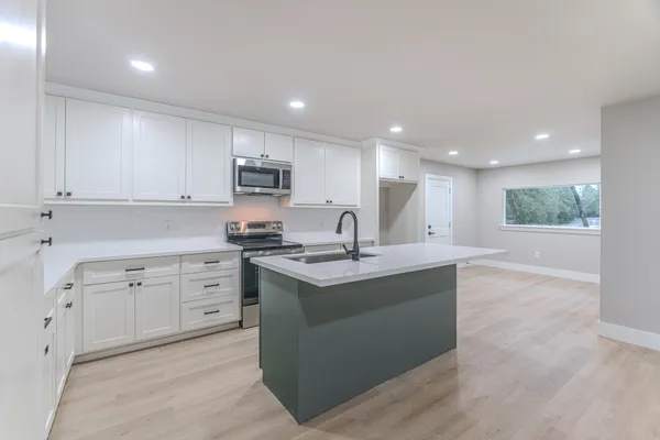 a kitchen with a sink stove and microwave
