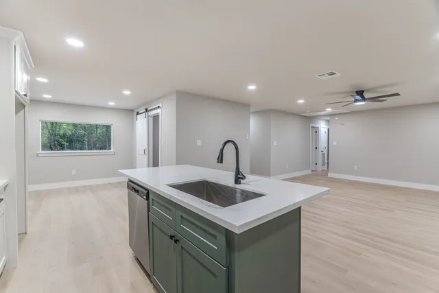 a view of kitchen island a sink wooden floor and entryway
