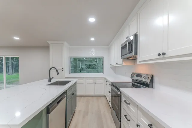 a kitchen with stainless steel appliances granite countertop a sink stove and cabinets