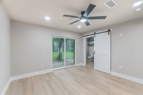 an empty room with closet and windows
