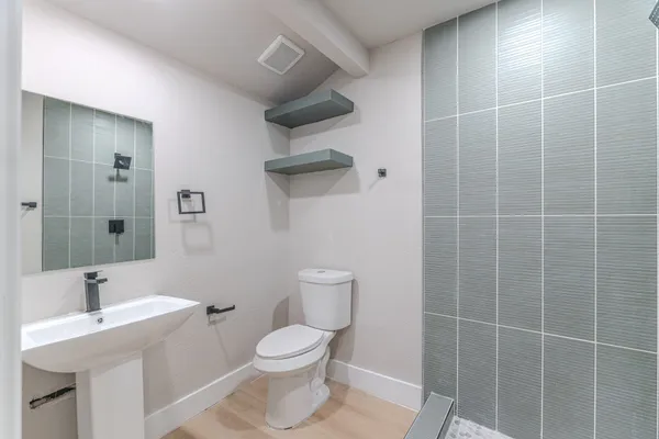 a bathroom with a toilet a sink and mirror