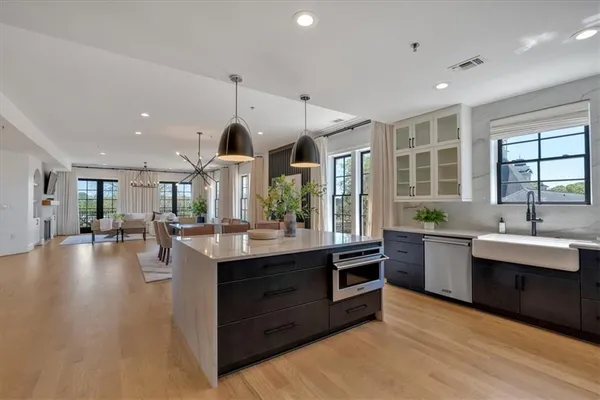 a living room with furniture large window and wooden floor