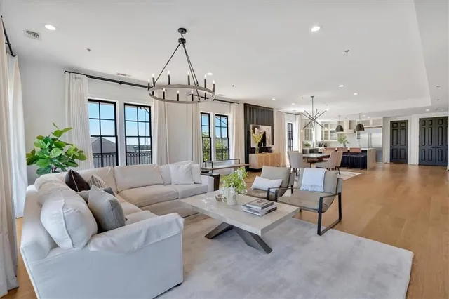 a spacious bedroom with a bed a couch and large window