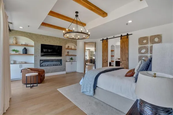 a bedroom with a large bed and a chandelier