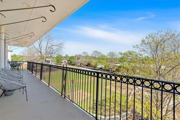an aerial view of a house with swimming pool and large trees