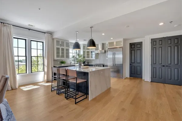 a large white kitchen with a large window and stainless steel appliances