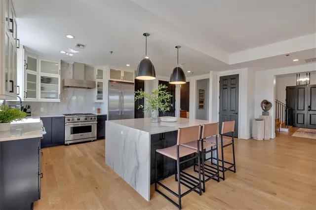 a large kitchen with kitchen island a sink stainless steel appliances and cabinets