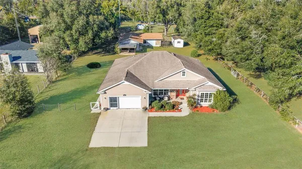 a front view of a house with a large window and potted plants