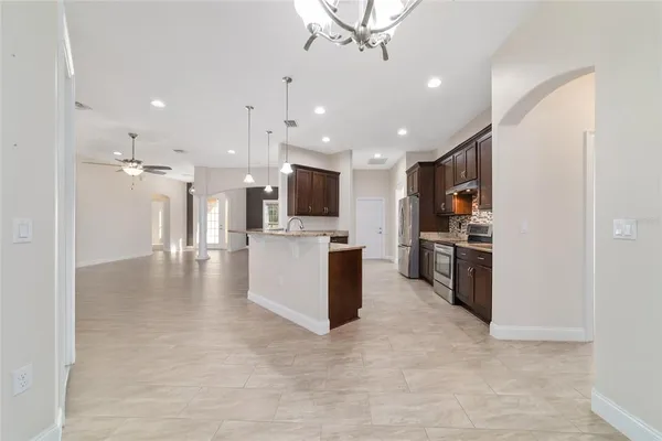 a view of a house with a big yard potted plants and large tree