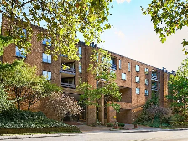 a front view of a multi story residential apartment building with a yard