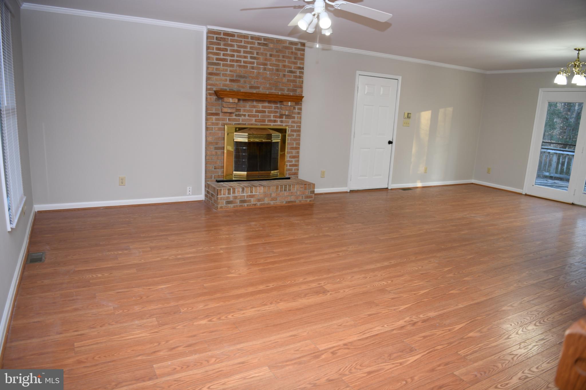 20503 Chestnut Ridge Drive Leonardtown, MD 20650 - Photo 9 of 36 a view of an empty room with wooden floor and a fireplace