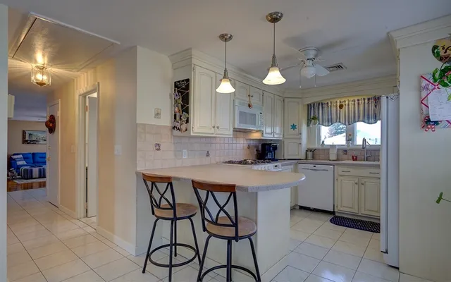 a kitchen with a dining table chairs cabinets and stainless steel appliances