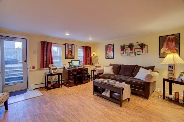 a living room with furniture a lamp and wooden floor
