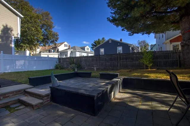 a view of a house with backyard and sitting area