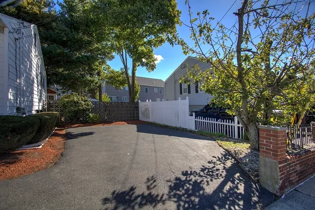 a view of a house with wooden fence and a bench