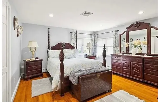 a bed room with a bed mirror and a dresser